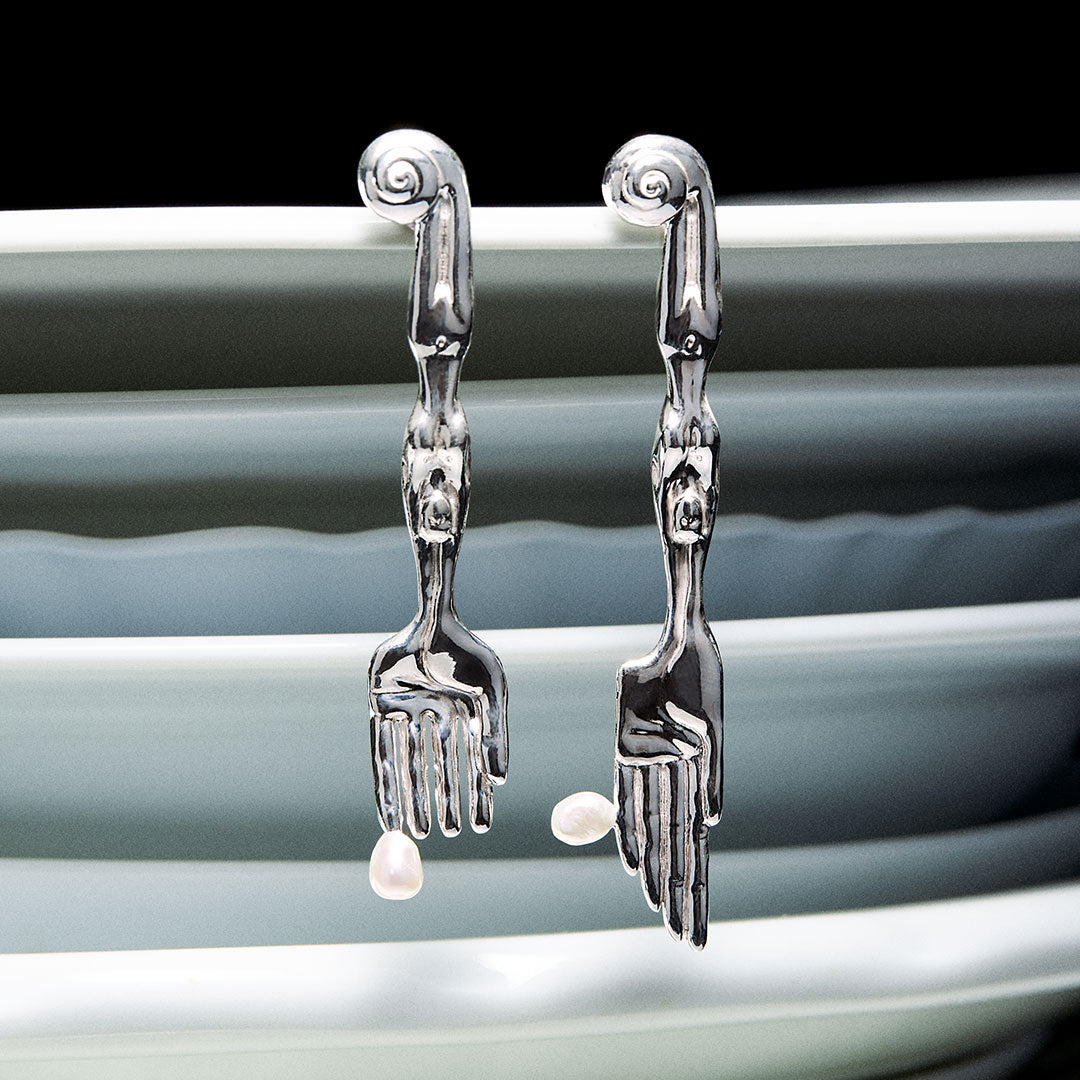 Earrings in sterling silver and natural pearls in surrealist fork and knife shapes with feminine bodies