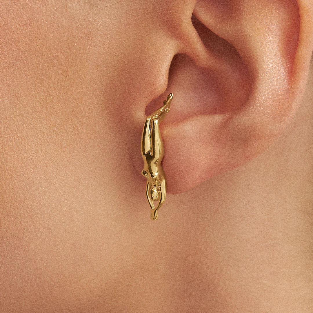 Model wearing earring in 925 silver with 18k gold plating of fa woman's body