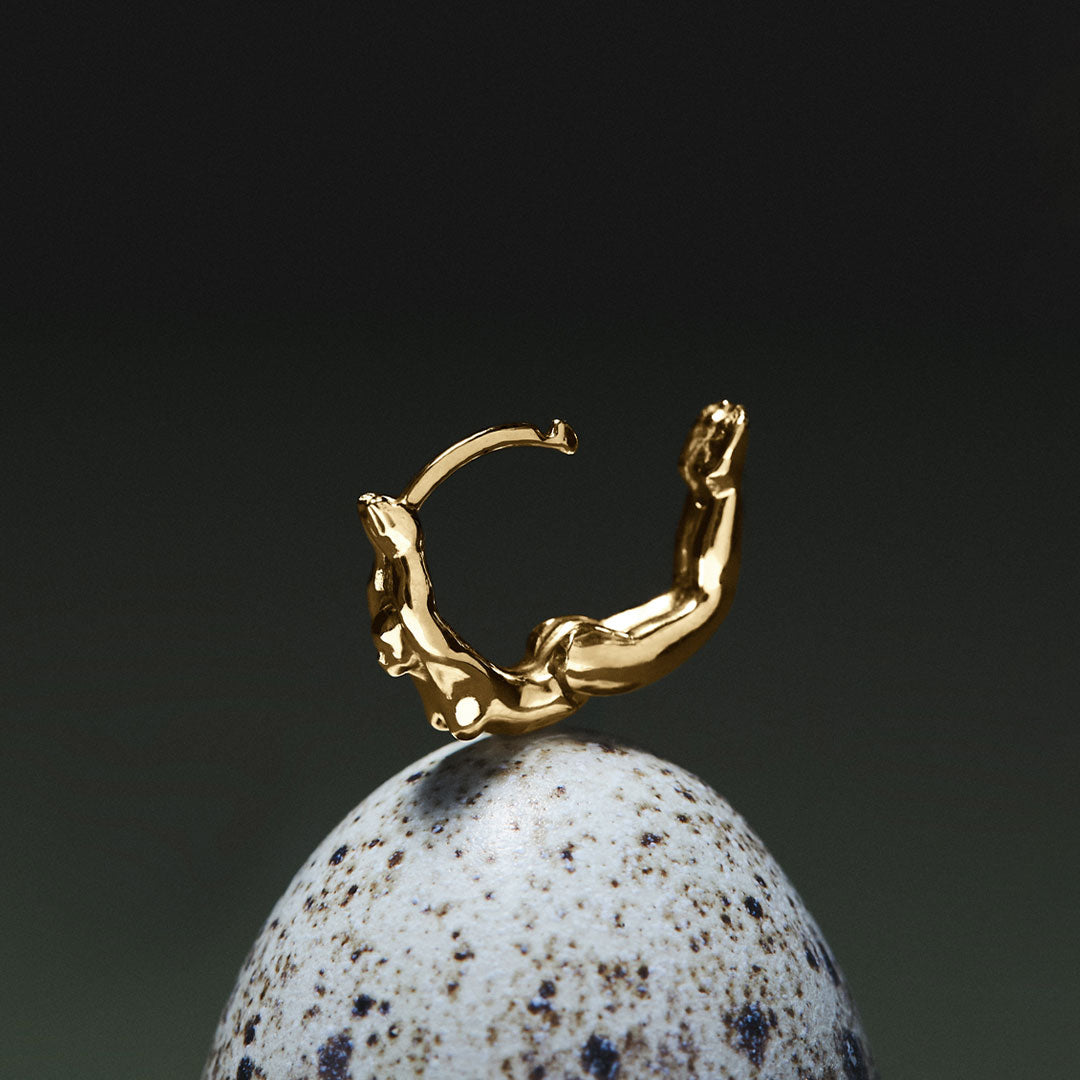 Hoop piercing in 18k gold of a female body