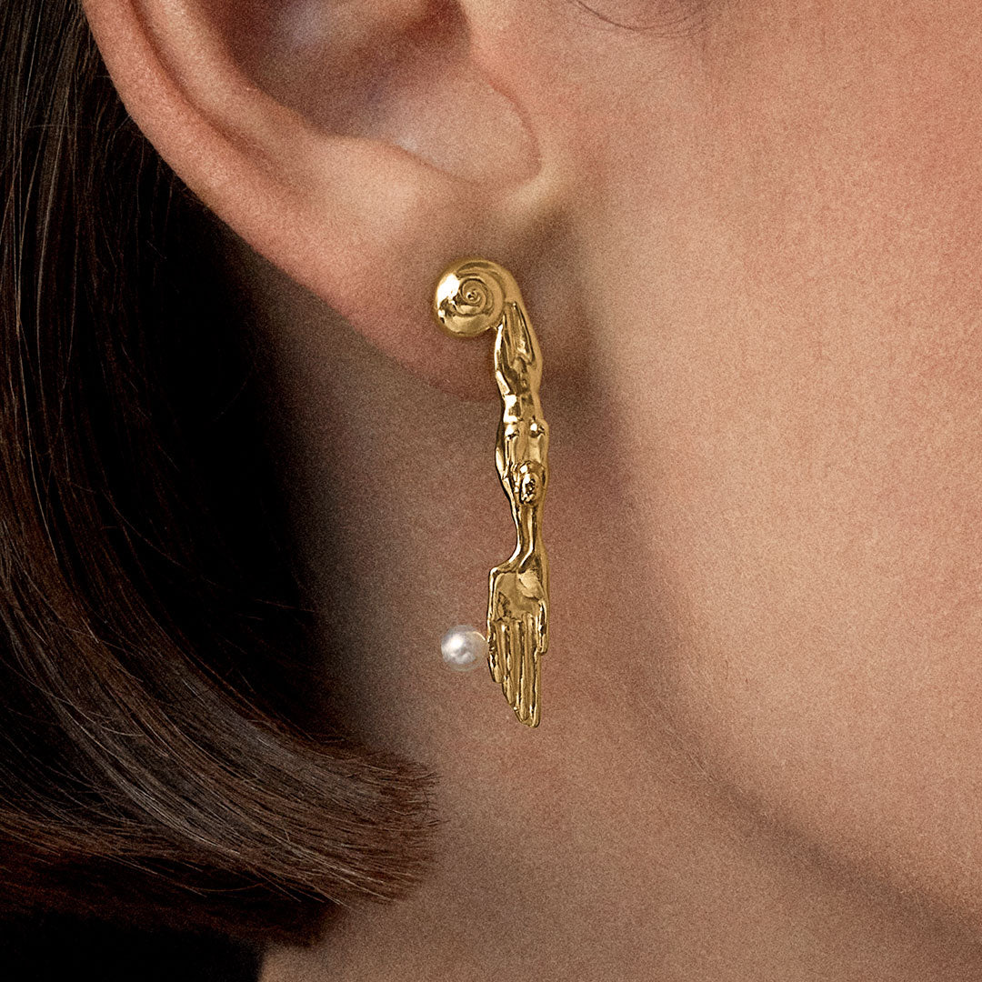 Model wearing 18k gold-plated sterling silver earring with natural pearl and mini surrealist knife