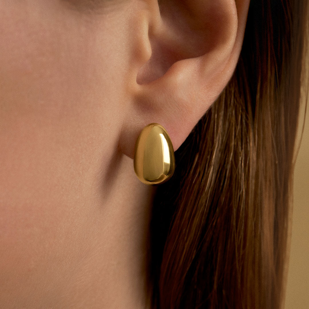 Model wearing egg earring in sterling silver with 18k gold plating
