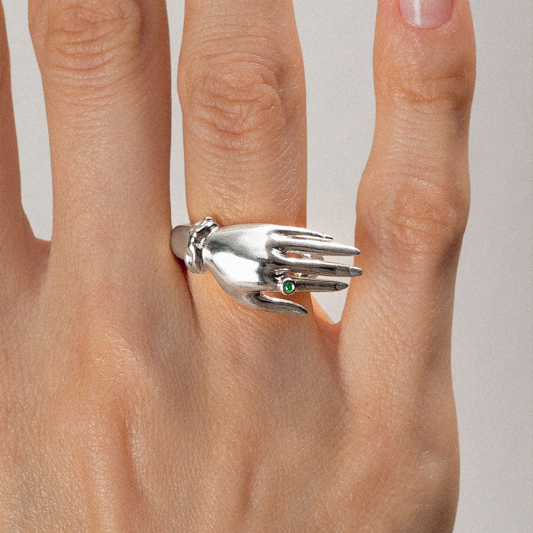 Model wearing a sterling silver hand ring with an emerald