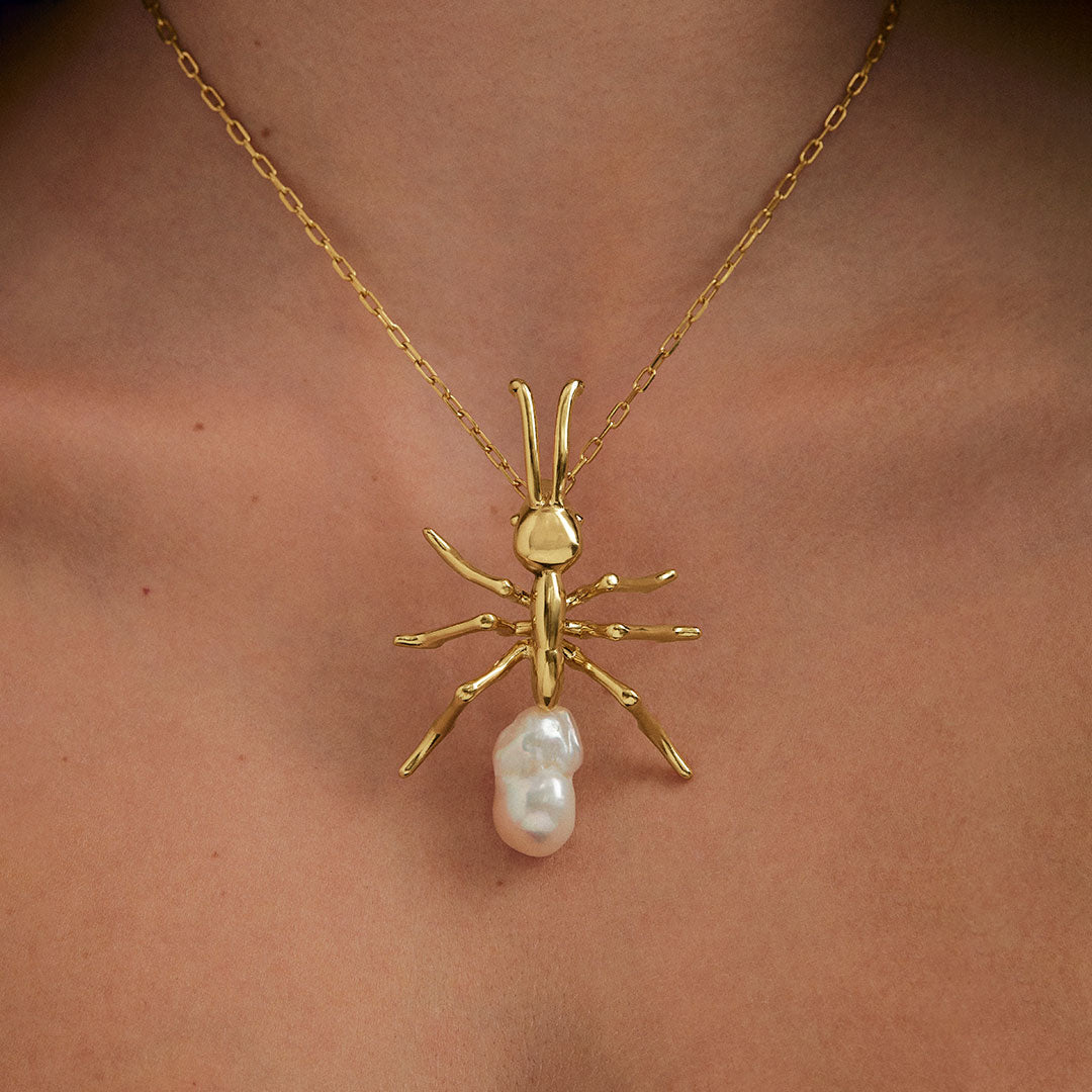 Model wearing large ant pendant on sterling silver chain with 18k gold plating