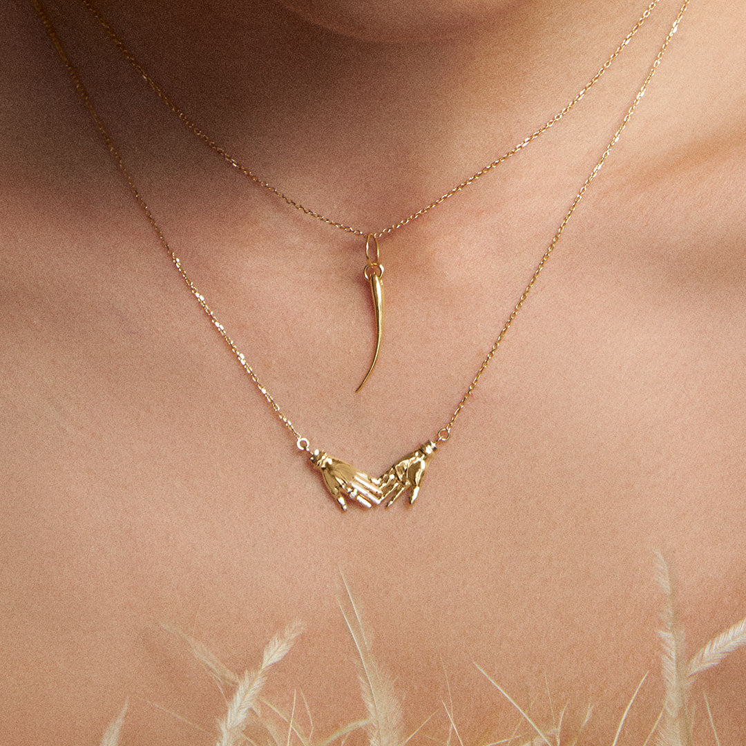 Model wearing 18k gold eyelash pendant on a chain