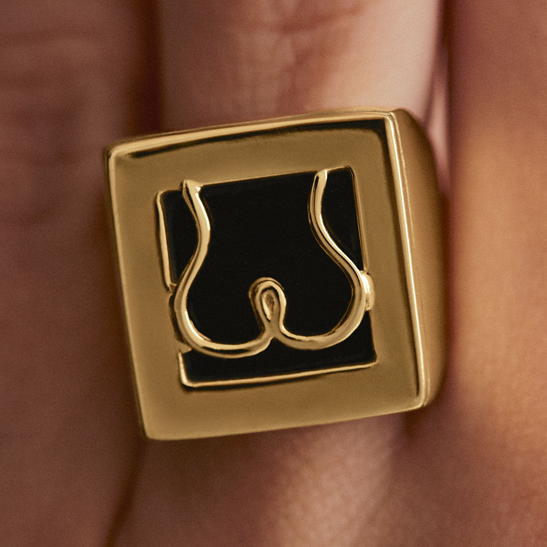 Model wearing Paola Vilas chevalier ring in sterling silver with 18k gold plating featuring an abstract butt
