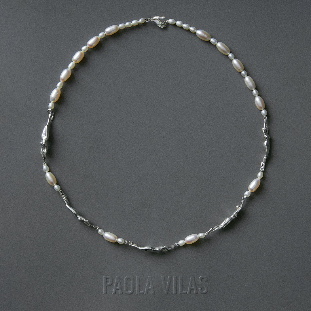 Necklace of feminine bodies in sterling silver and pearls with hand-shaped clasp adorned with emerald