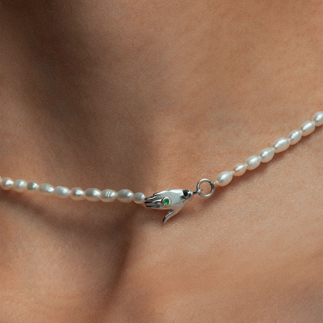 Model wearing Paola Vilas necklace in sterling silver with emerald and pearls