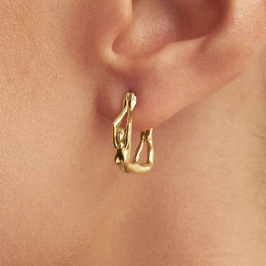 Model wearing 18k gold mini hoop earring of female body