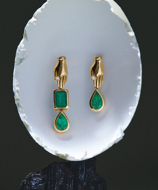 Asymmetrical 18k gold hand earrings adorned with emeralds and diamonds