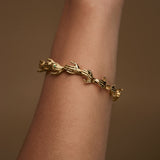 Model wearing hand-shaped bracelet in sterling silver chain with 18k gold plating