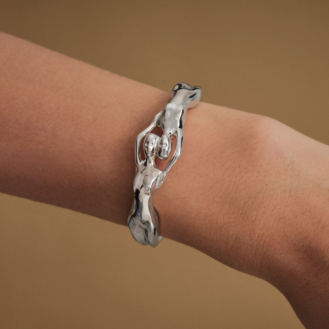 Model wearing sterling silver bracelet with fused female bodies