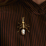 Model wearing large ant brooch in sterling silver with 18k gold plating and baroque pearl
