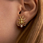 Model wearing ant earring in sterling silver with 18k gold plating and pearls