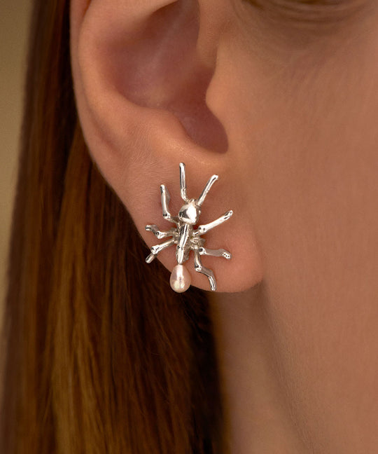 Model wearing ant earring in sterling silver with pearls
