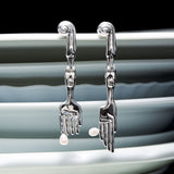 Earrings in sterling silver and natural pearls in surrealist fork and knife shapes with feminine bodies
