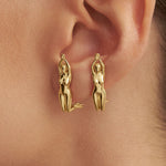 Model wearing earrings of sculptures of women in 925 silver with 18k gold plating