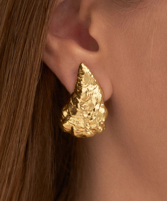 Model wearing large oyster earring in sterling silver with 18k gold plating