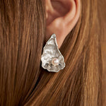 Model wearing large oyster earring in sterling silver with pearl