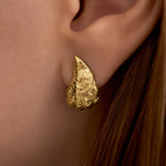 Model wearing small oyster earring in sterling silver with 18k gold plating