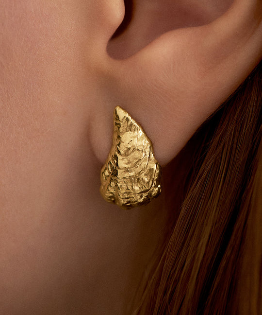 Model wearing small oyster earring in sterling silver with 18k gold plating