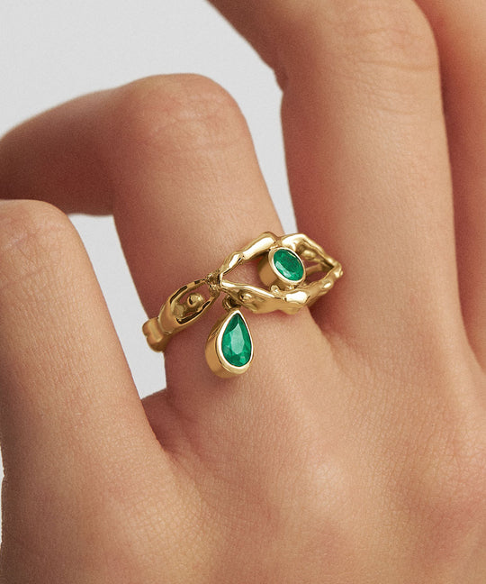 Model wearing eye ring with tear and bodies in 18k gold and emeralds