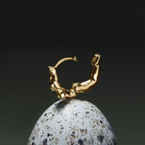 Hoop piercing in 18k gold of a female body