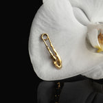 Sterling silver earring with 18k gold plating featuring a safety pin and female body