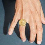 Model wearing a chevalier ring in sterling silver with 18k gold plating of a flying fish
