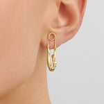 Model wearing sterling silver earring with 18k gold plating featuring a safety pin and female body