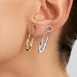 Model wearing sterling silver earrings with 18k gold plating featuring safety pins and female bodies