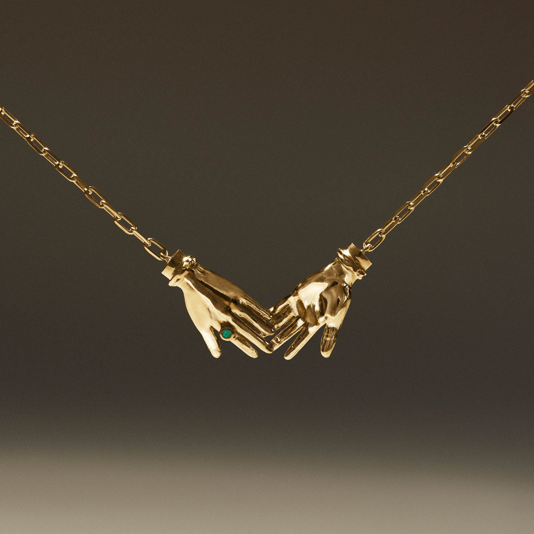 Joined hands necklace in sterling silver with 18k gold plating and emerald