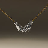 Joined hands necklace in sterling silver with 18k gold-plated chain and emerald