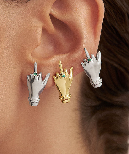 Model wearing sterling silver middle finger earrings with 18k gold plating and emerald
