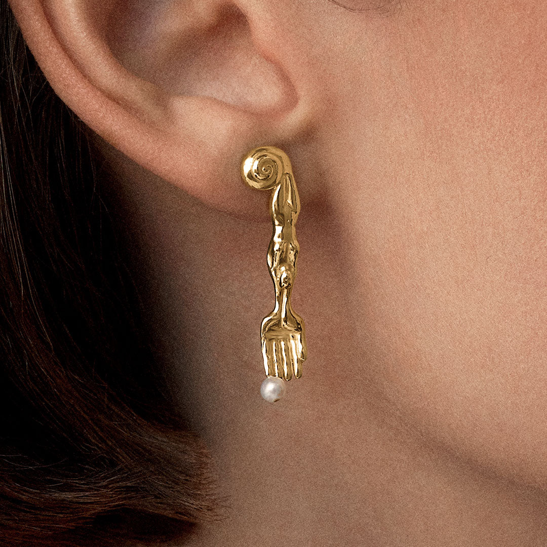 Model wearing 18k gold-plated sterling silver earring with natural pearl and mini surrealist fork