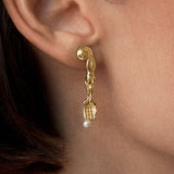 Model wearing 18k gold-plated sterling silver earring with natural pearl and mini surrealist fork