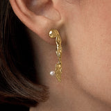 Model wearing 18k gold-plated sterling silver earring with natural pearl and mini surrealist knife