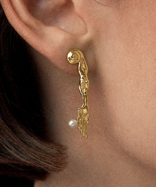 Model wearing 18k gold-plated sterling silver earring with natural pearl and mini surrealist knife
