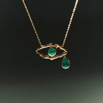 18k gold necklace of eye and female bodies adorned with emeralds