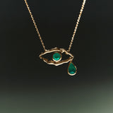 18k gold necklace of eye and female bodies adorned with emeralds