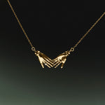 18k gold necklace of hands adorned with diamond