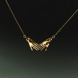 18k gold necklace of hands adorned with diamond