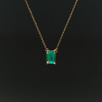 18k gold necklace with rectangular emerald and sculpted hands