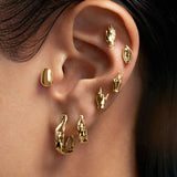 Model wearing 18k gold and diamond piercings