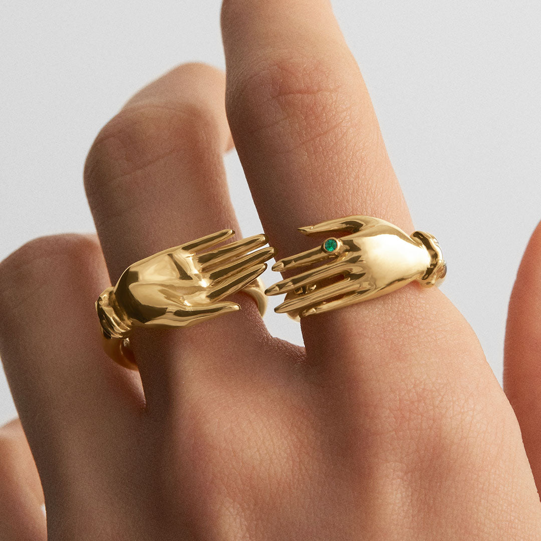 Model wearing sterling silver hand rings with 18k gold plating and emeralds