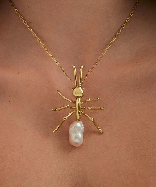 Model wearing large ant pendant on sterling silver chain with 18k gold plating
