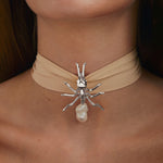 Model wearing large sterling silver ant pendant with baroque pearl on silk ribbon