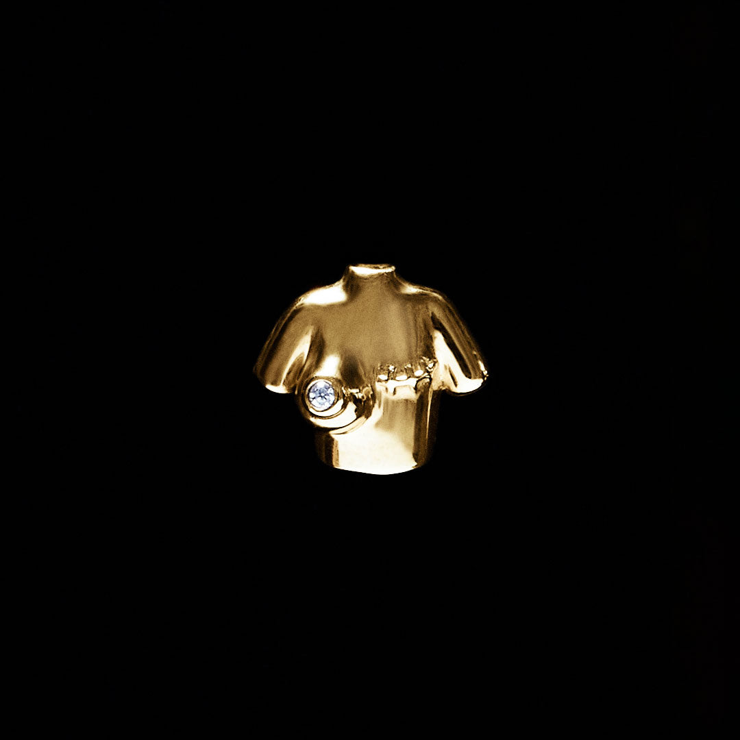 18k gold female bust piercing adorned with a diamond