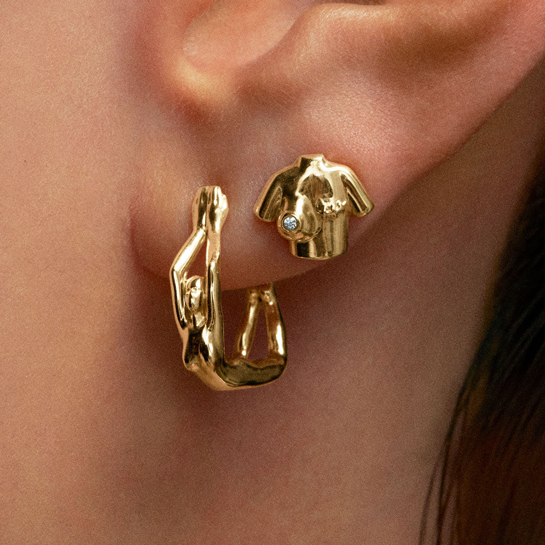 Model wearing 18k gold earrings and piercings of female bodies