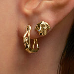 Model wearing 18k gold earrings and piercings of female bodies