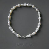 Baroque pearl necklace with sterling silver hand detail adorned with emerald